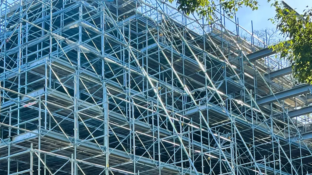 Real construction scaffold showing standards, ledgers, diagonal bracing and multiple working platform levels.