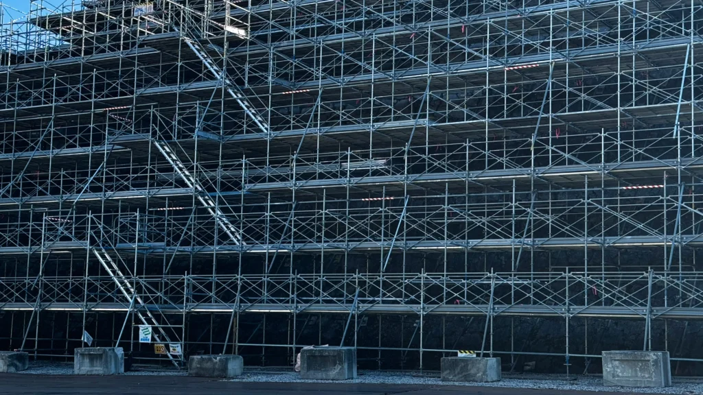 Real scaffold elevation showing multiple bays, working levels, diagonal bracing and external stair access on a building facade.