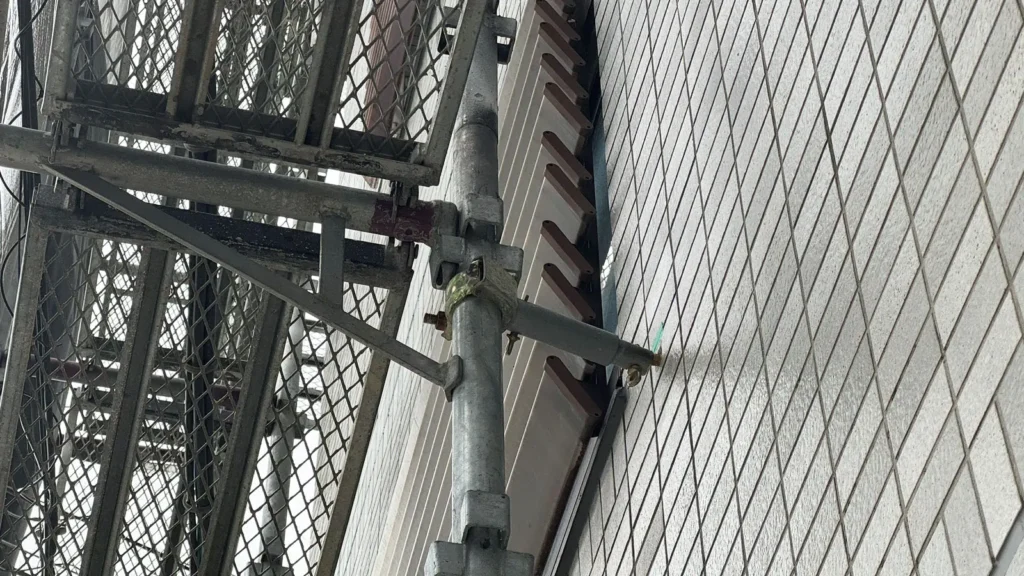 Real scaffold tie connecting an external scaffold to a building wall on a construction site.