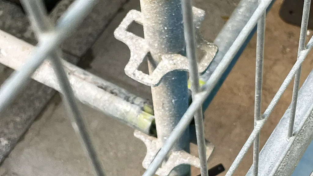 Close-up of a scaffold tie connection and metal scaffold components showing a practical connection detail on a construction scaffold.