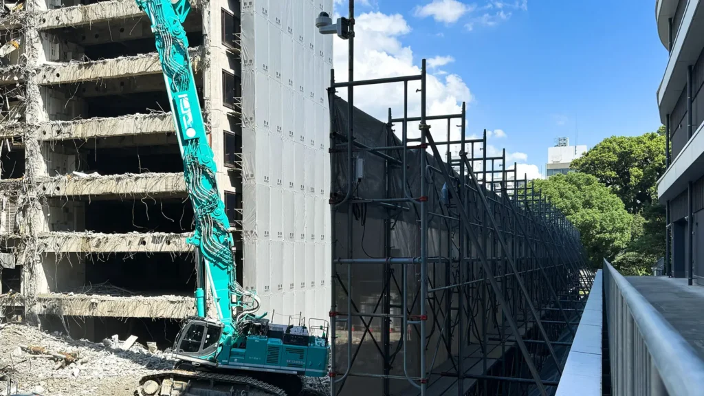 Scaffold beside a building during demolition showing changing structural and site conditions