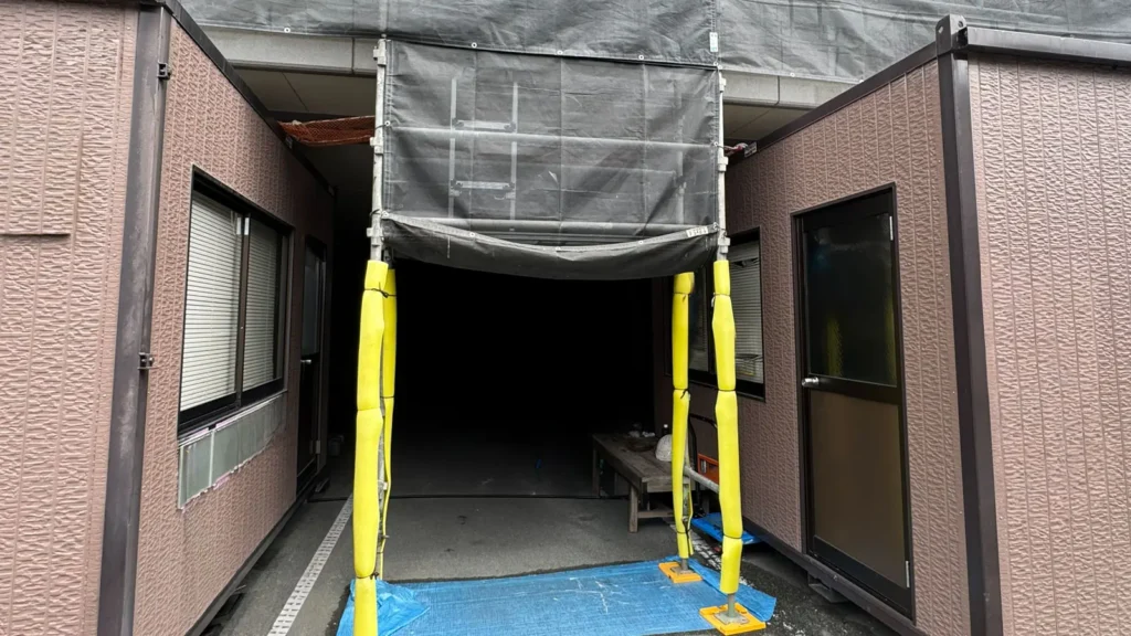 Scaffold access opening maintained between buildings with standards positioned on both sides