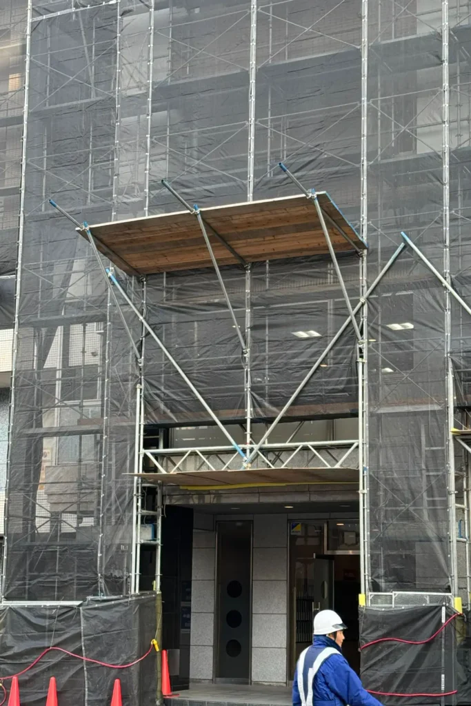 Scaffold bridging arrangement above a building entrance opening