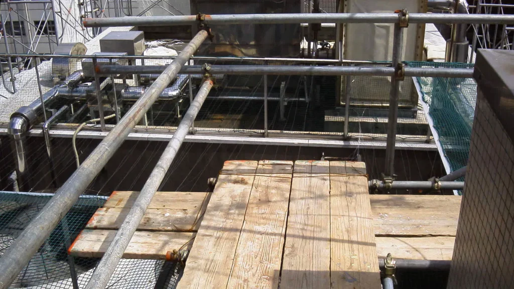Scaffold working platform arrangement around a building corner with guardrails and tube connections