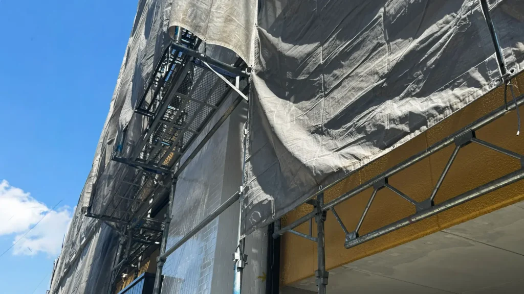 Scaffold installed around a building projection showing a site condition that must be checked before drawing issue