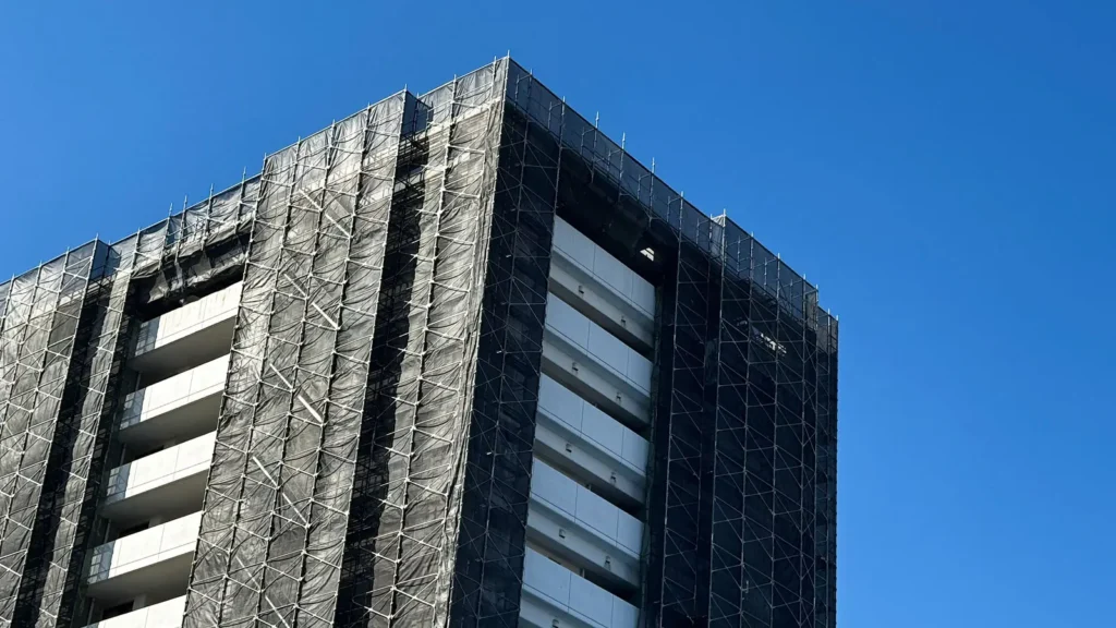 Real scaffold elevation showing standards, ledgers, bracing and protective sheeting
