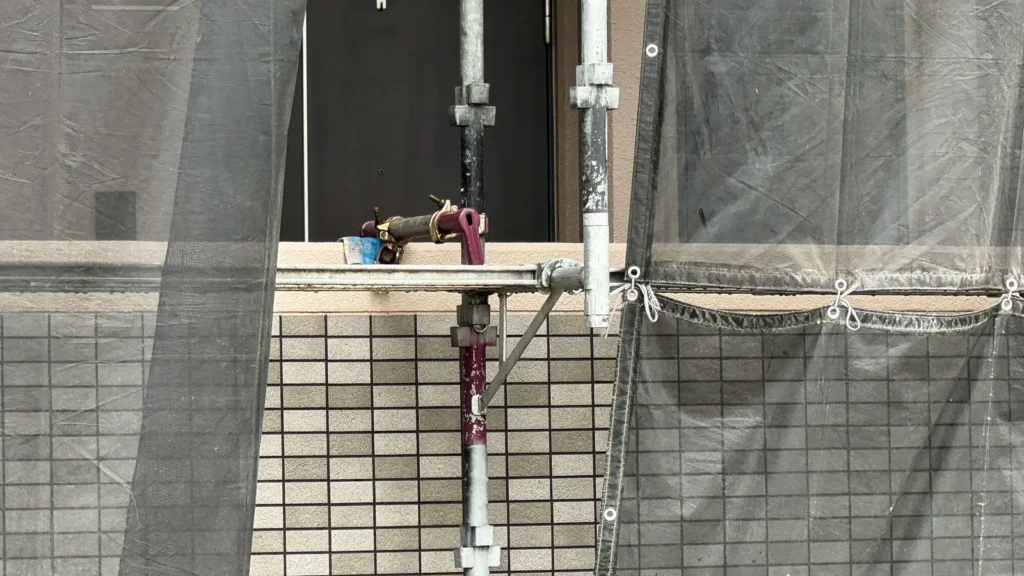 Existing pipes and scaffold components positioned close to a building wall, showing an easy-to-miss scaffold drawing detail