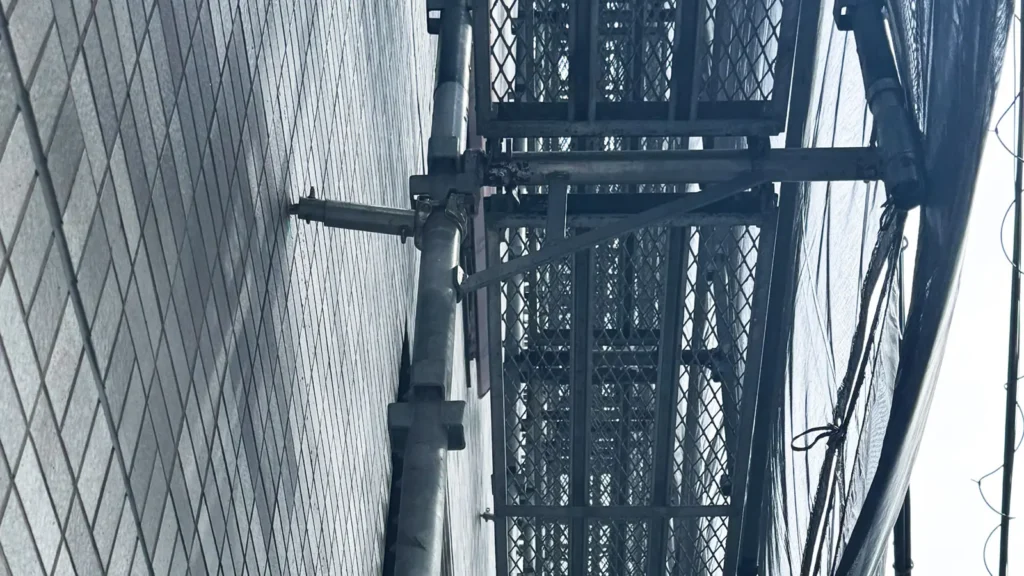 Scaffold working platform beside a building showing platform-to-structure clearance and bracket support