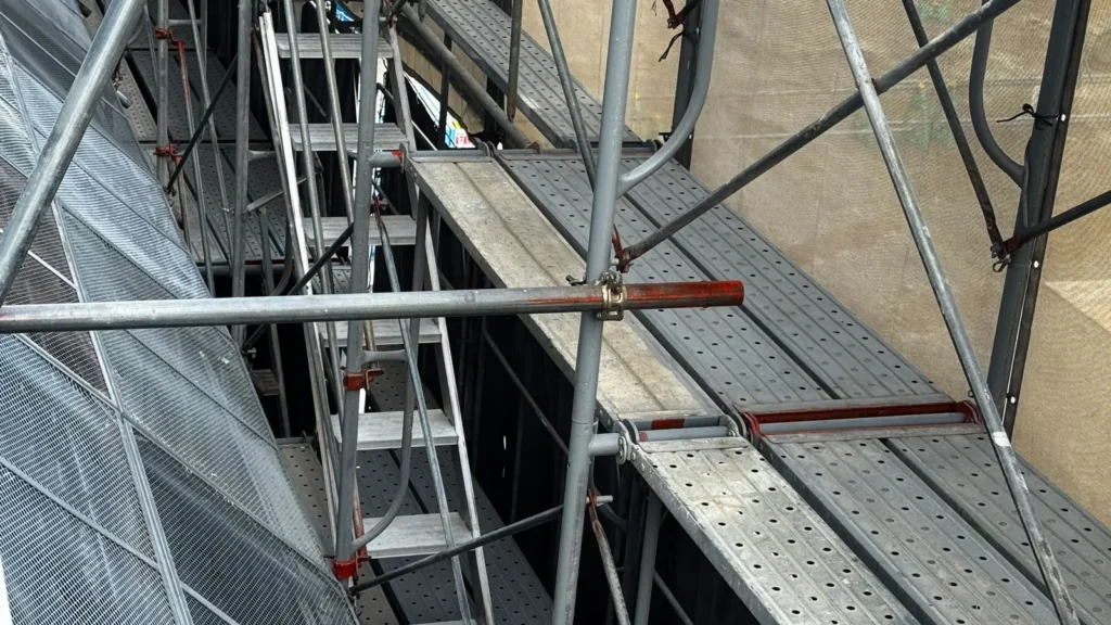 Close-up view of scaffold working platforms and structural components showing complex on-site coordination.