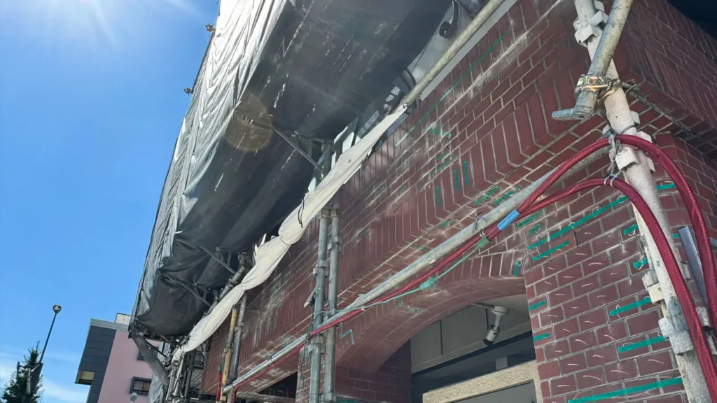 Scaffold installed around a building facade and opening showing complex site conditions to review after drawing revisions