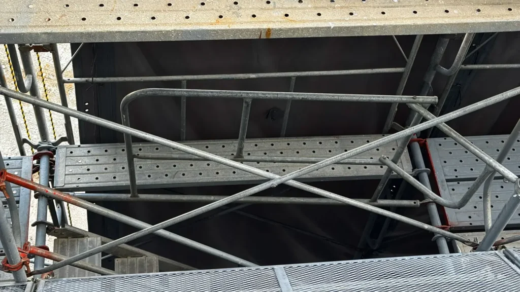 Close-up view of a scaffold stair landing connected to the working platform