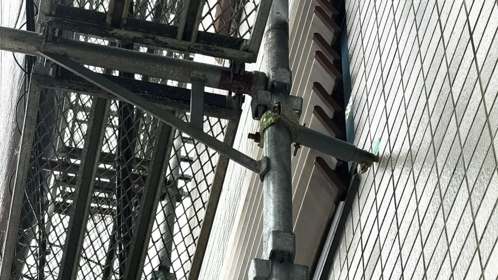 Scaffold tie connection between scaffold standard and building wall