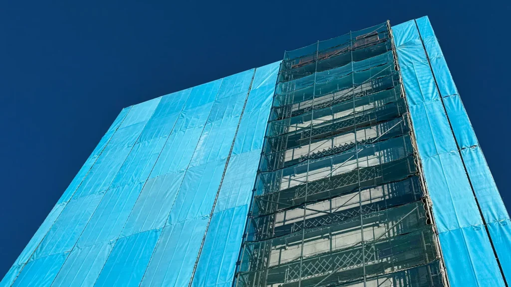 Scaffold enclosed with two different types of sheeting and mesh