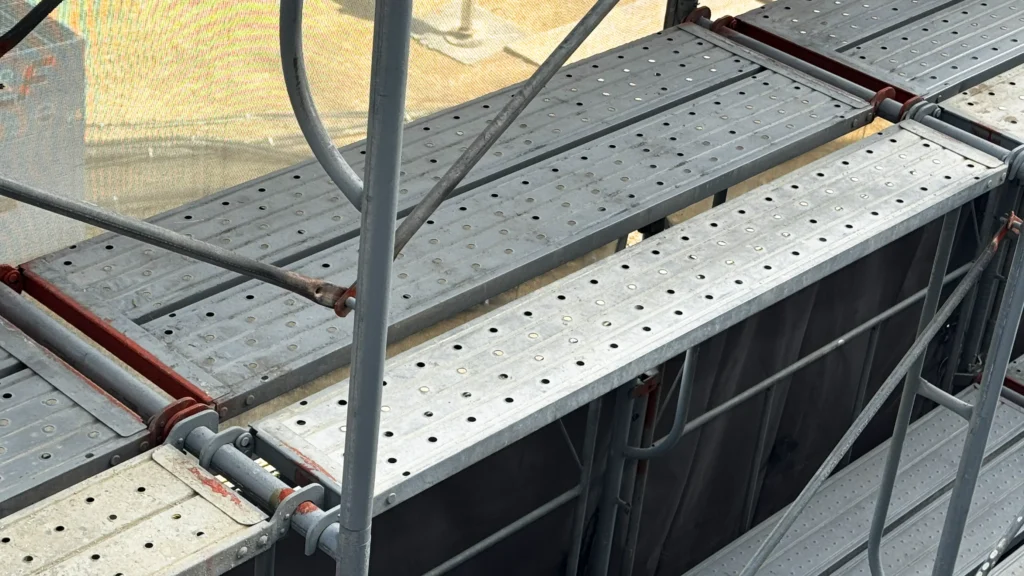 Metal scaffold working platforms supported within a multi-level scaffold structure.